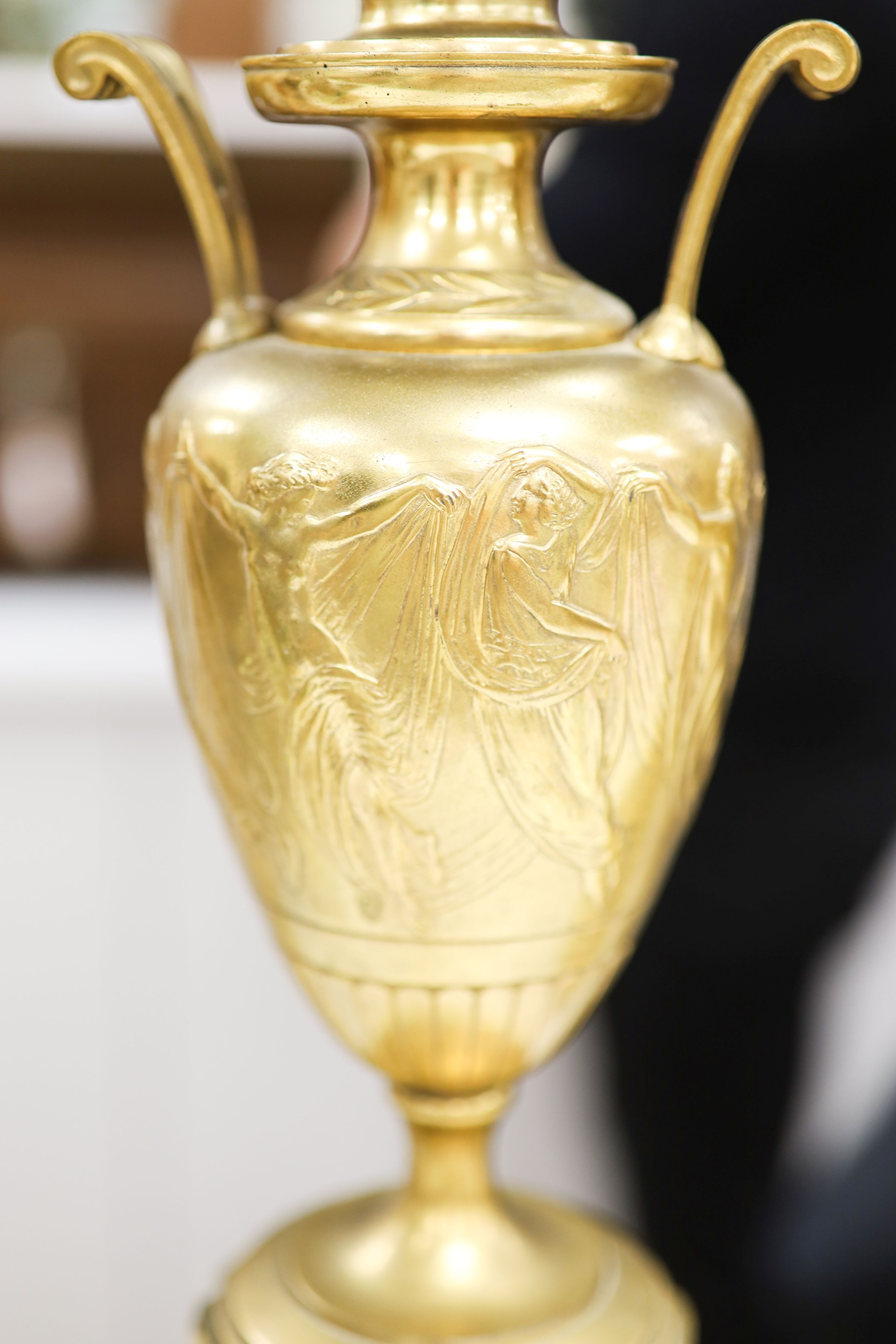A pair of Louis XVI style four branch, five light gilt brass candelabra, with vase shaped stem, on shaped alabaster plinths 76cm